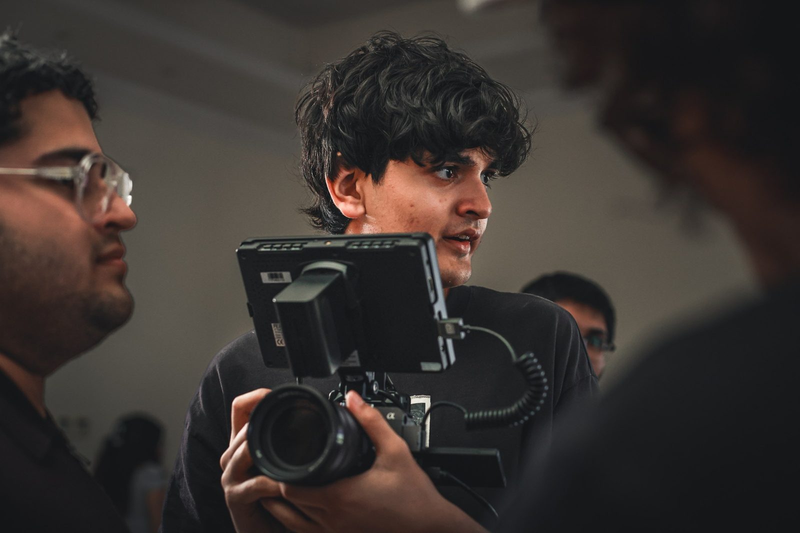 A camera operator holds a cinema camera on set