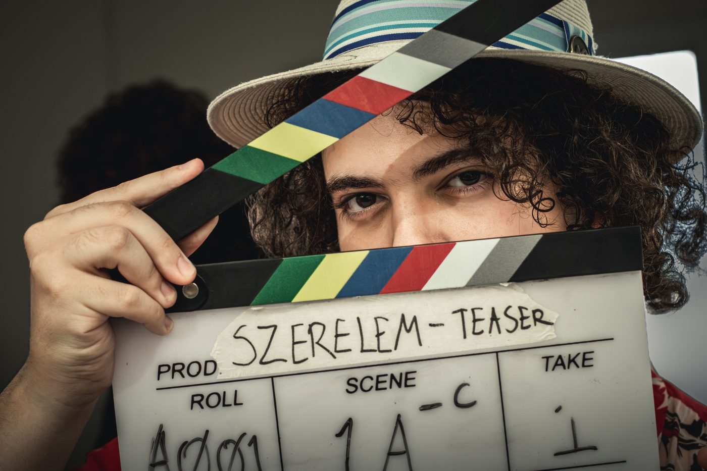 Clapperboard reading Szerelem teaser held up in front of an actor