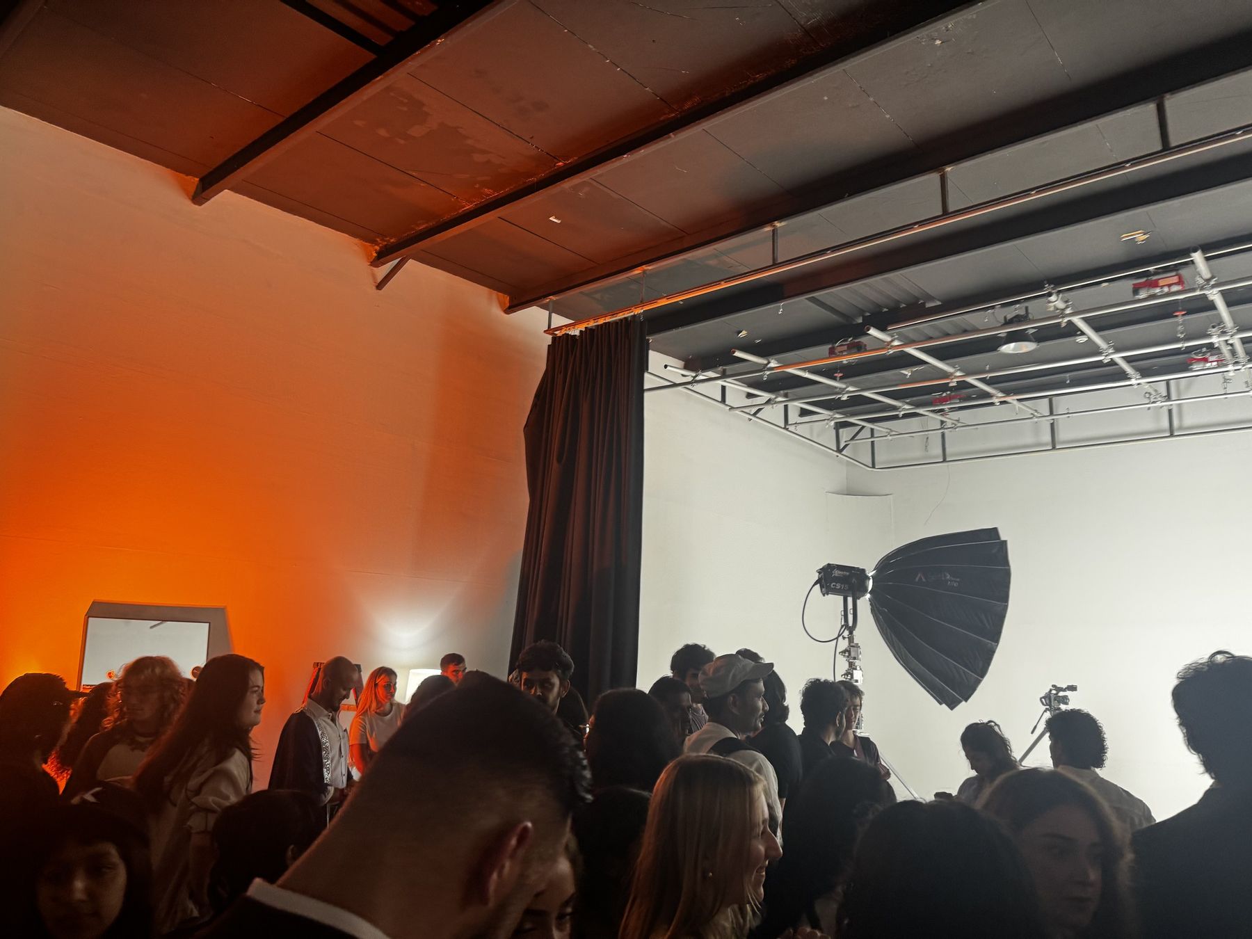 A packed studio during Kaleido's open casting day, lit in warm orange